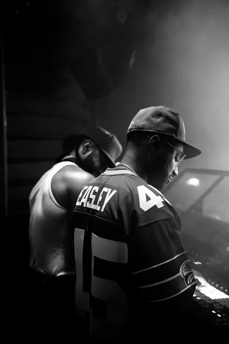 DJs behind the booth in a smoke-filled club