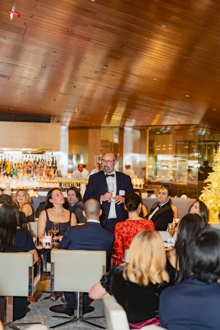 Host speaking to the room at a holiday dinner