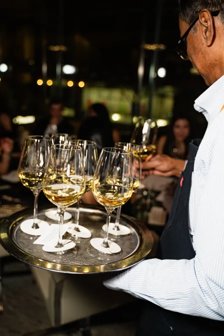 Server carrying a tray of white wine
