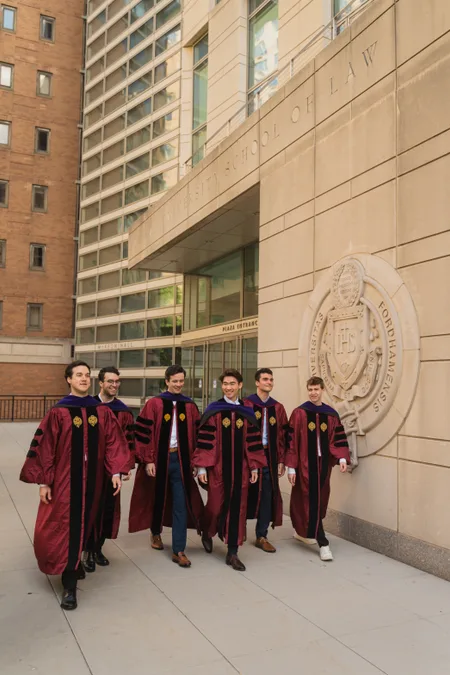 Graduates walking out of Fordham Law in full regalia