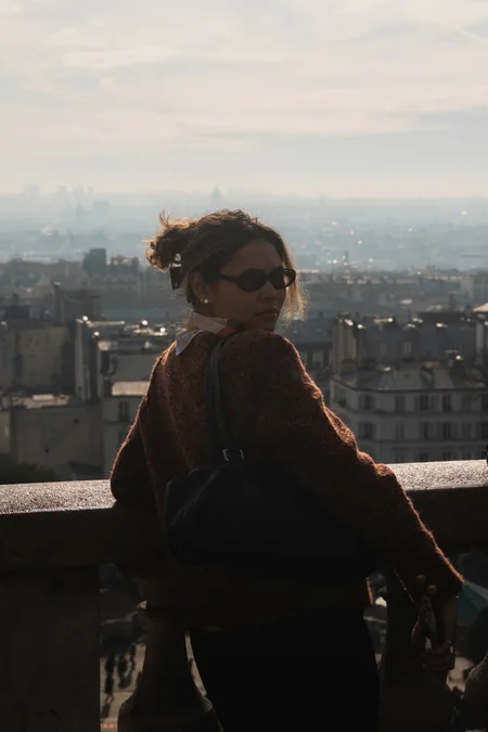 Woman looking back over the rooftops of Paris