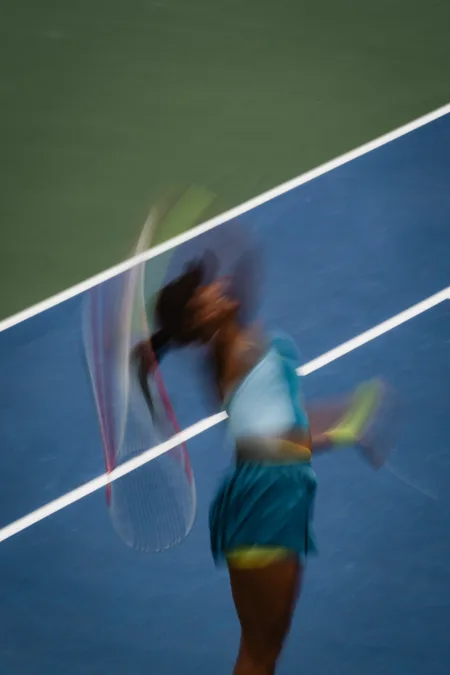 A blurred swing across the service line, panned during the stroke