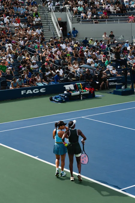 Two players walking the baseline in front of a full stand