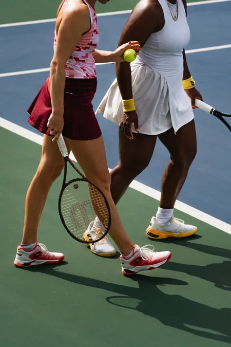 Kateřina Siniaková and another player crossing at the change of ends