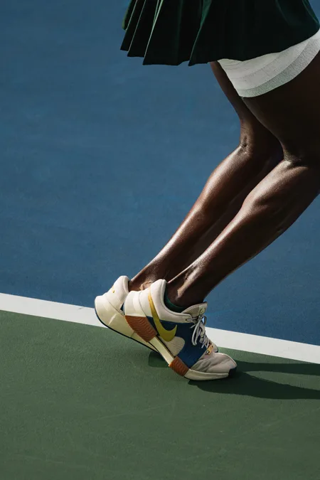 A player up on her toes at the baseline, seen from the knees down