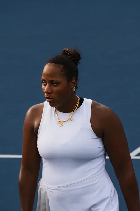 A player in a white dress looking off court between points