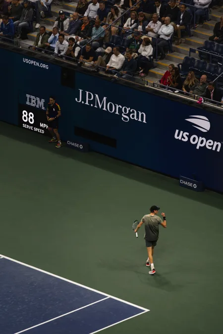 A player crossing the court under the sponsor wall at the US Open