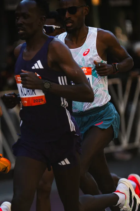 Korir running shoulder to shoulder with a rival through Manhattan