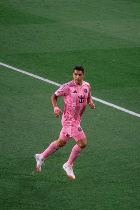 An Inter Miami player running upfield in the pink kit