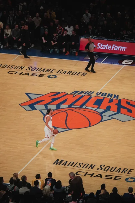 A Knicks player bringing the ball up over the Madison Square Garden centre logo